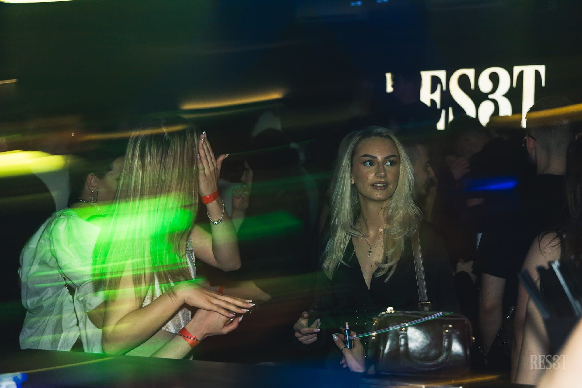 Zelene svetlobne sledi okoli ostrih obrazov na plesišču