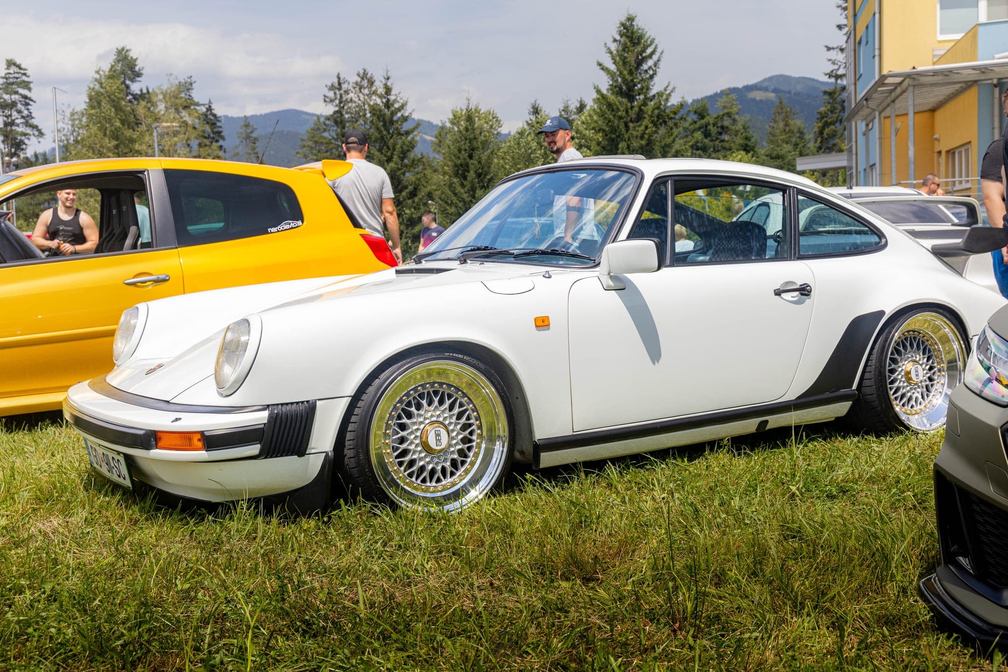 Bel Porsche 911 s platišči BBS na travniku